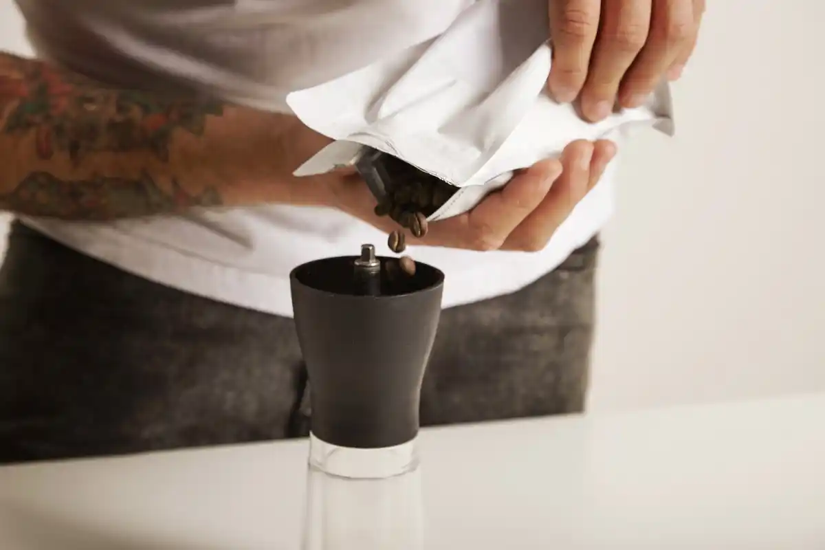 barista hand holding coffee cup and salt shaker