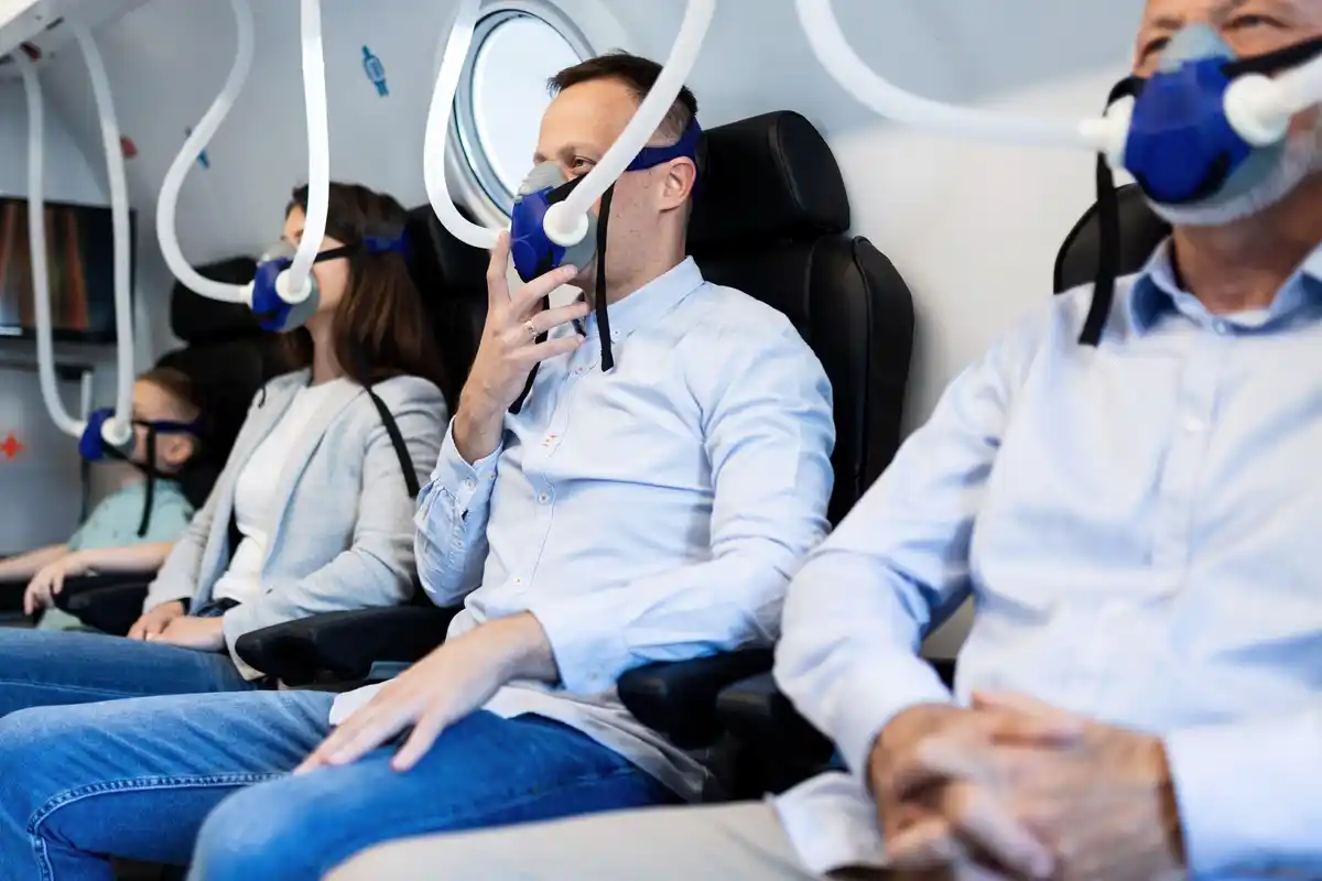 passenger using overhead air vent on airplane seat