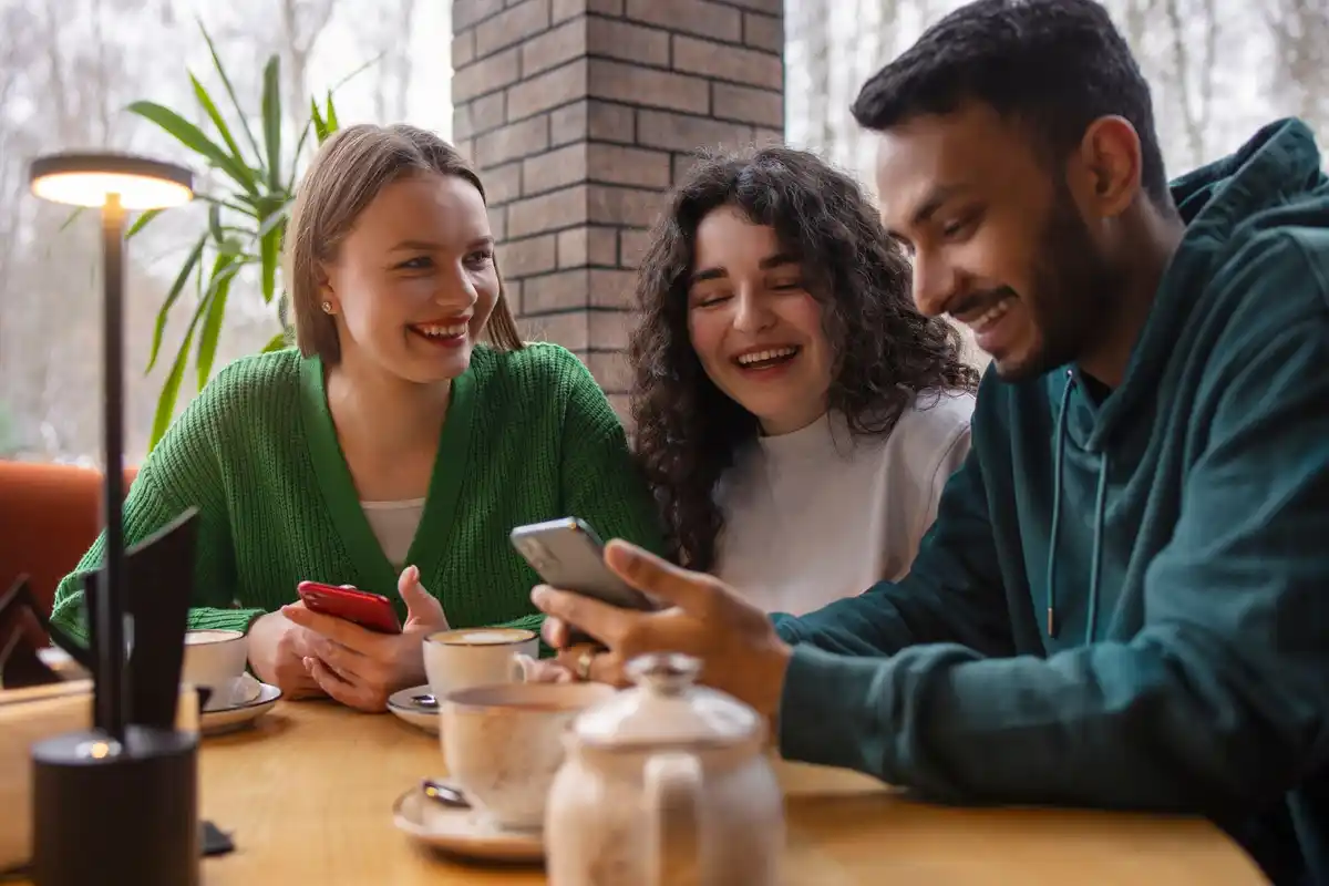phone turned off on café table, group of friends conversing, Dutch bar interior