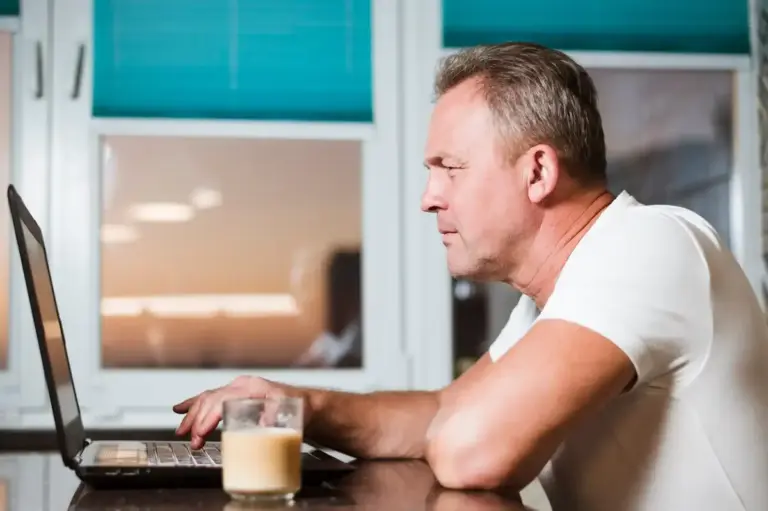 Dutch person distracted while working on laptop