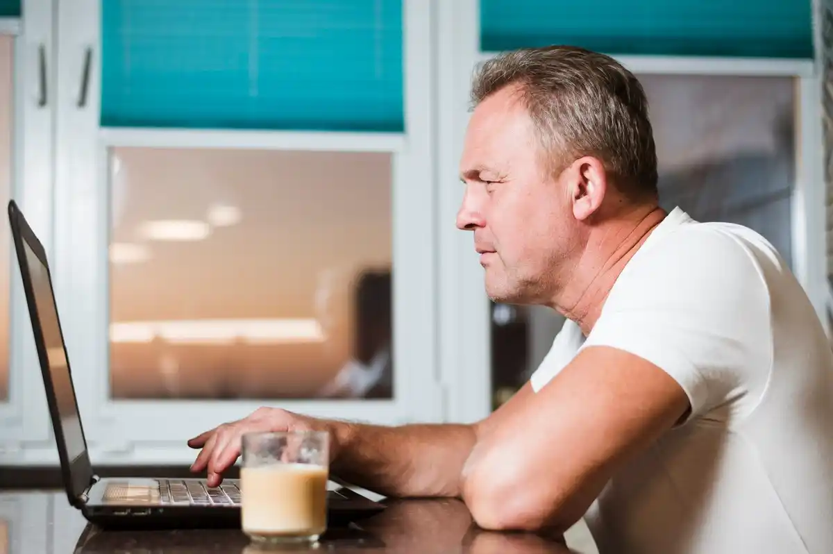 Dutch person distracted while working on laptop