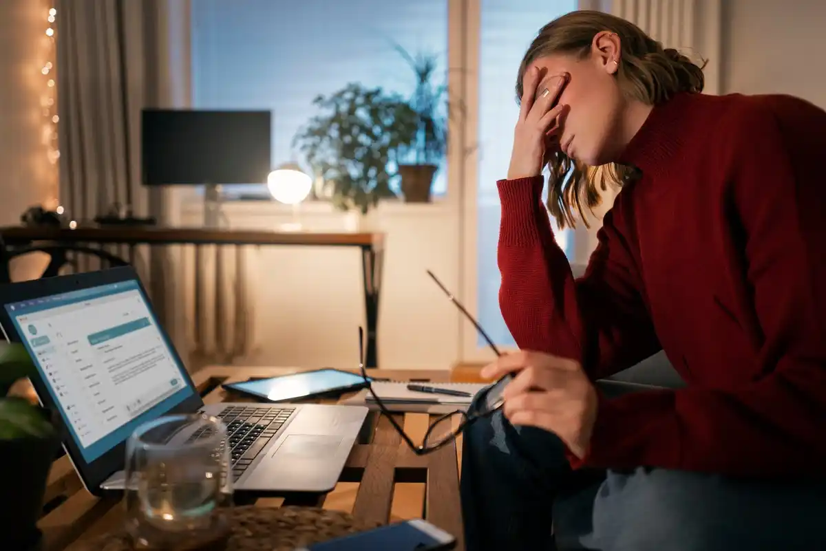stressed person at computer multiple devices multitasking