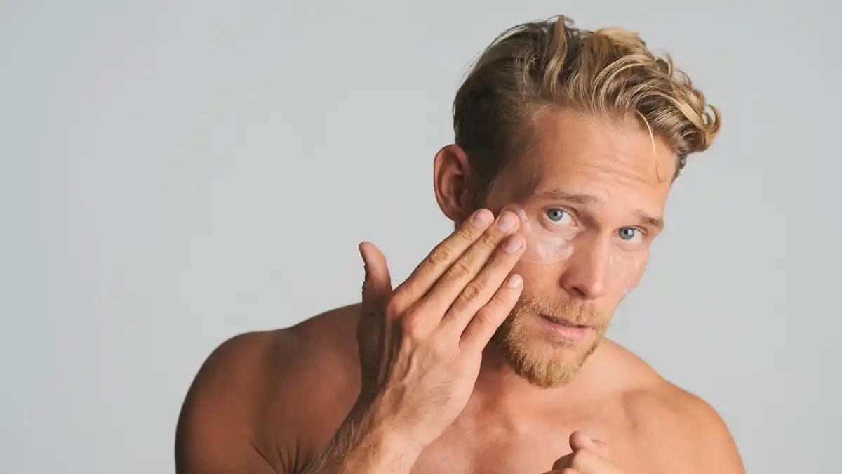 close up man applying eye cream under eyes bathroom鏂眯豸