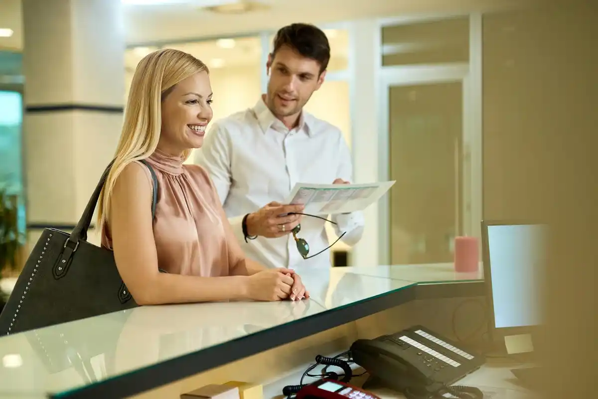 hotel manager talking with guest at Dutch reception desk
