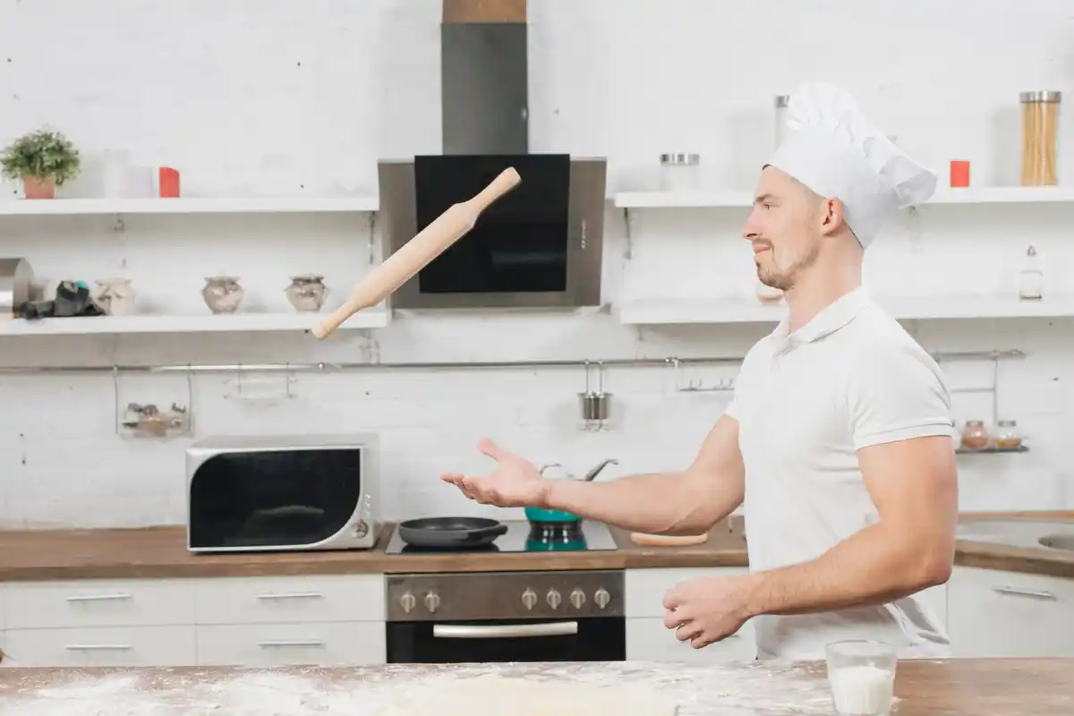Man choosing between microwave and oven in Dutch kitchen, humorous mood