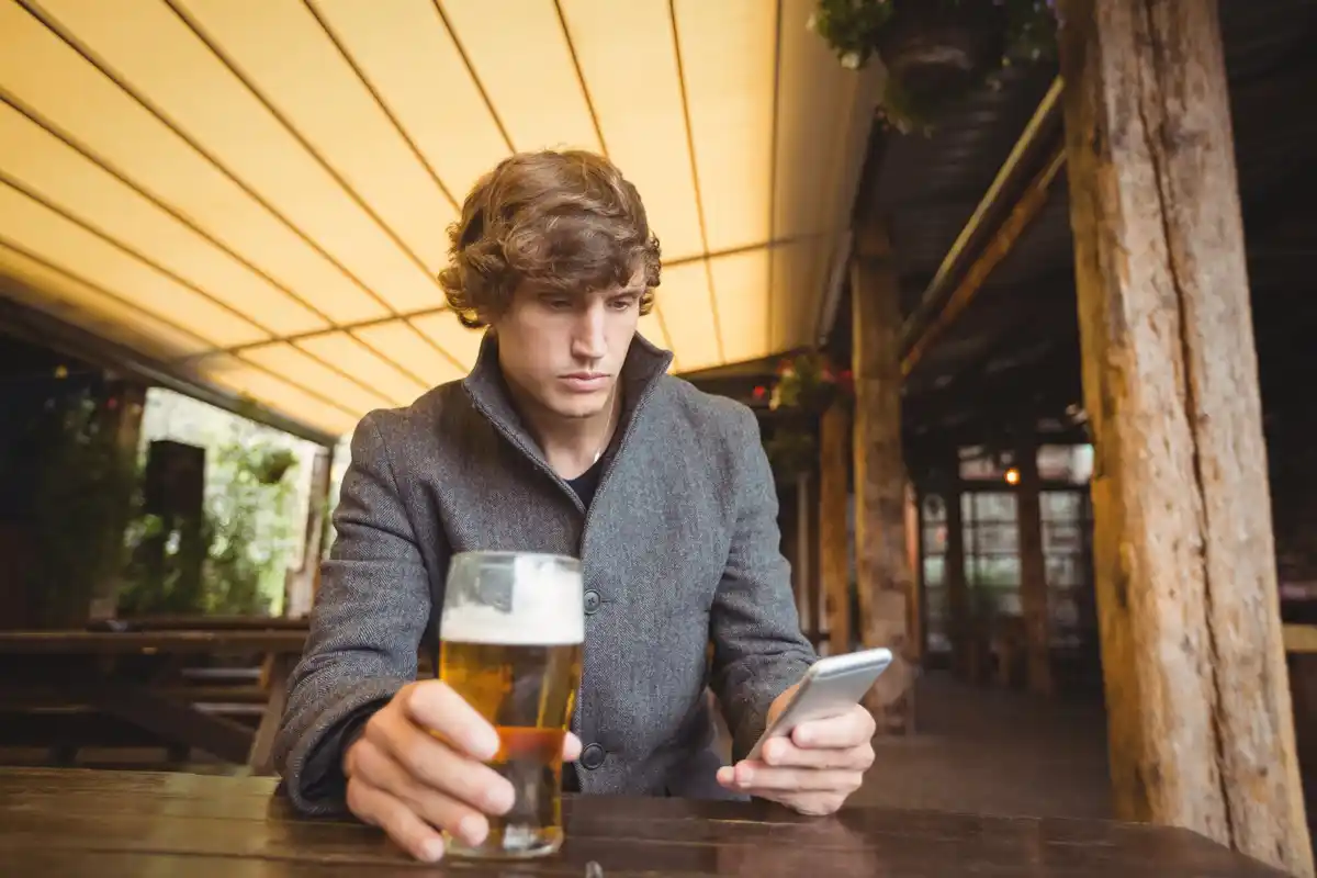 young introvert texting at party Netherlands