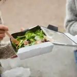 young traveler picking up too good to go surprise food box mediterranean city