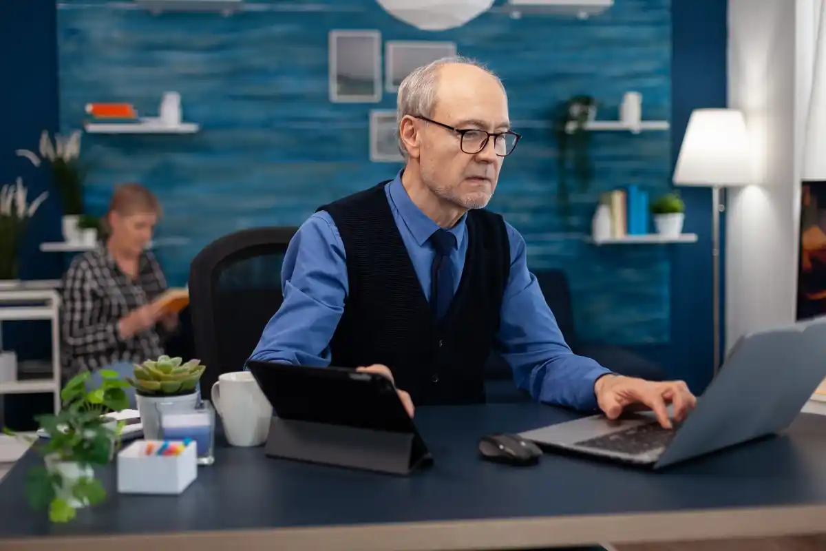 dutch office worker over 50 closing a laptop at the end of the workday