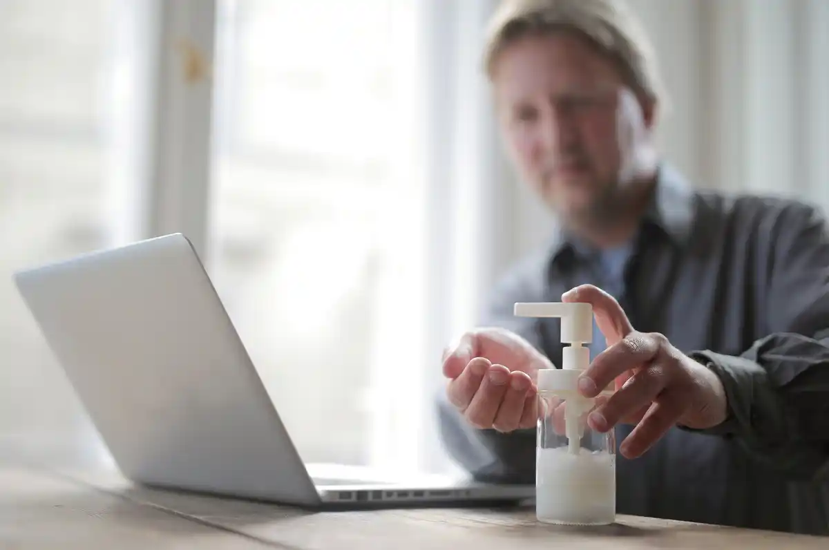 Dutch person cleaning hands with sanitizer in modern home