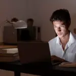 tired Dutch student night study home laptop