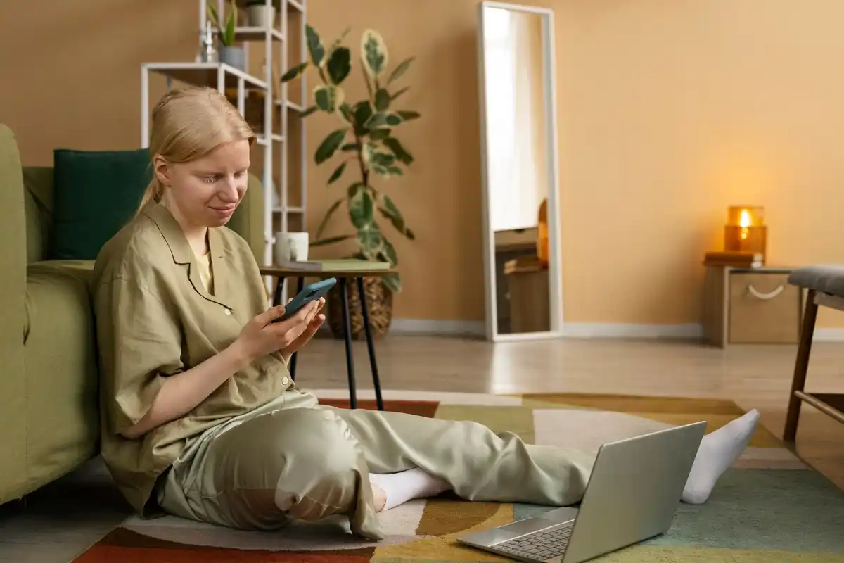dutch person multitasking at home with smartphone and laptop