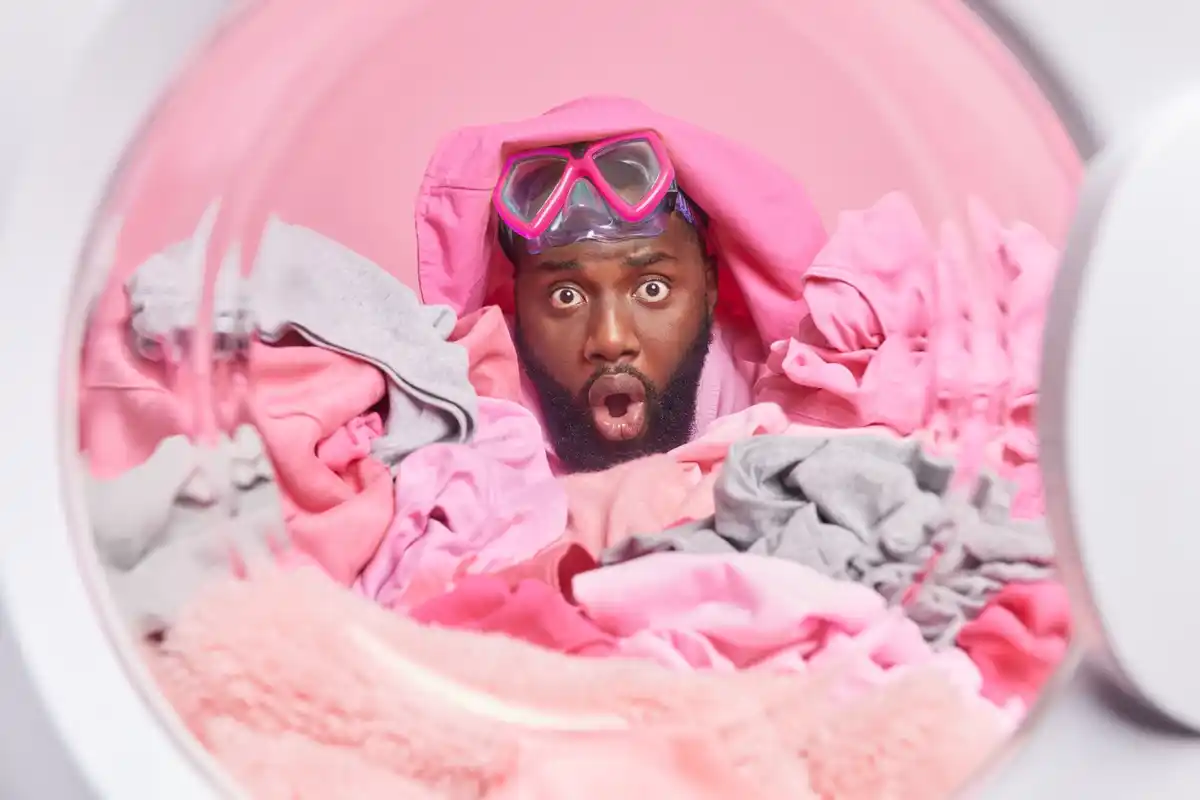 mixed laundry in washing machine, colorful clothes disaster