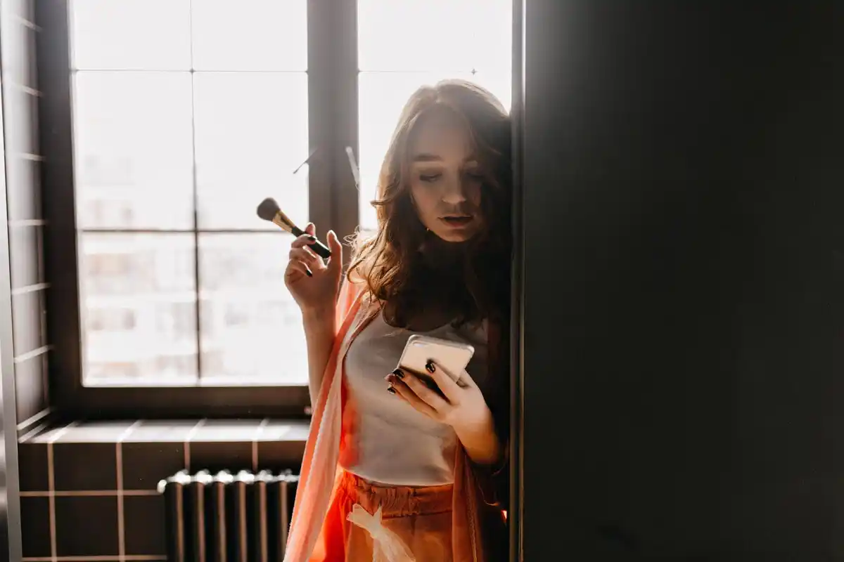 Dutch woman applying makeup mirror home natural light