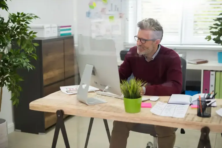 man focusing at desk in busy dutch office