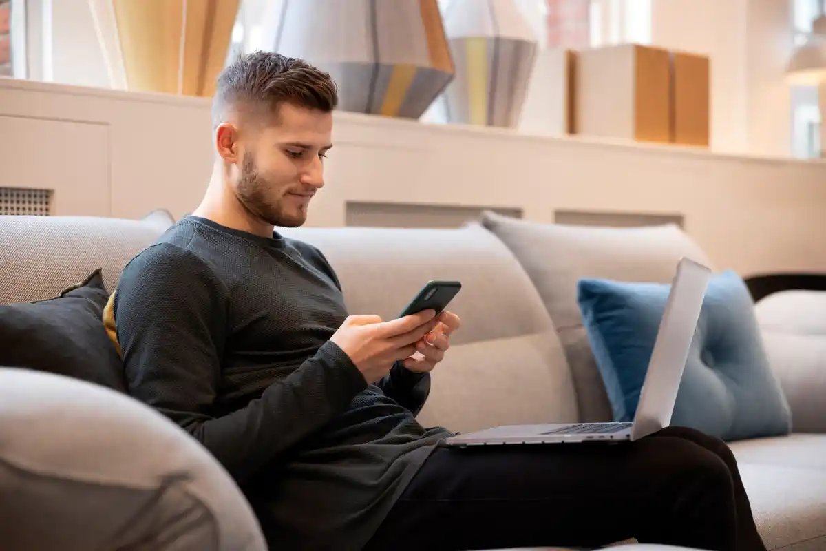 dutch man checking subscription apps on smartphone home