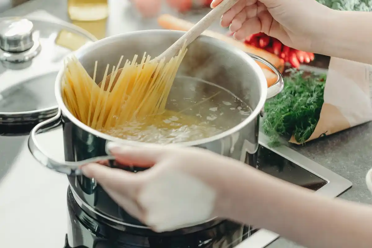 creamy pasta mixing in pan with starchy pasta water