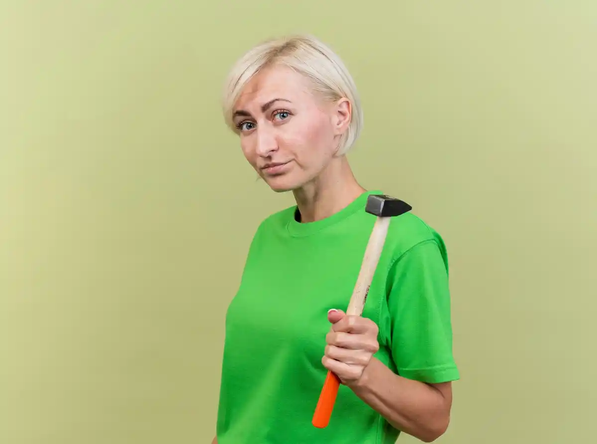 Dutch woman over 50 with cleaning equipment looking thoughtful