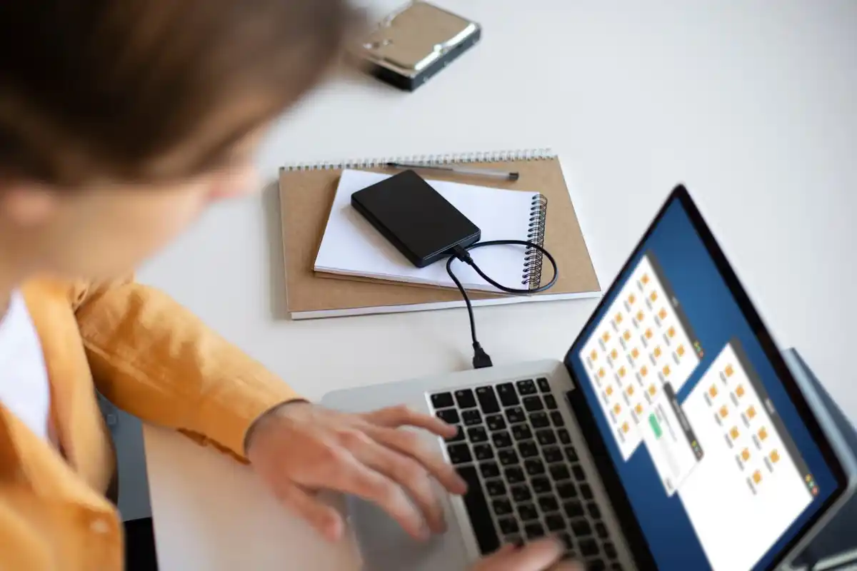 woman using laptop with many open browser tabs messy workspace