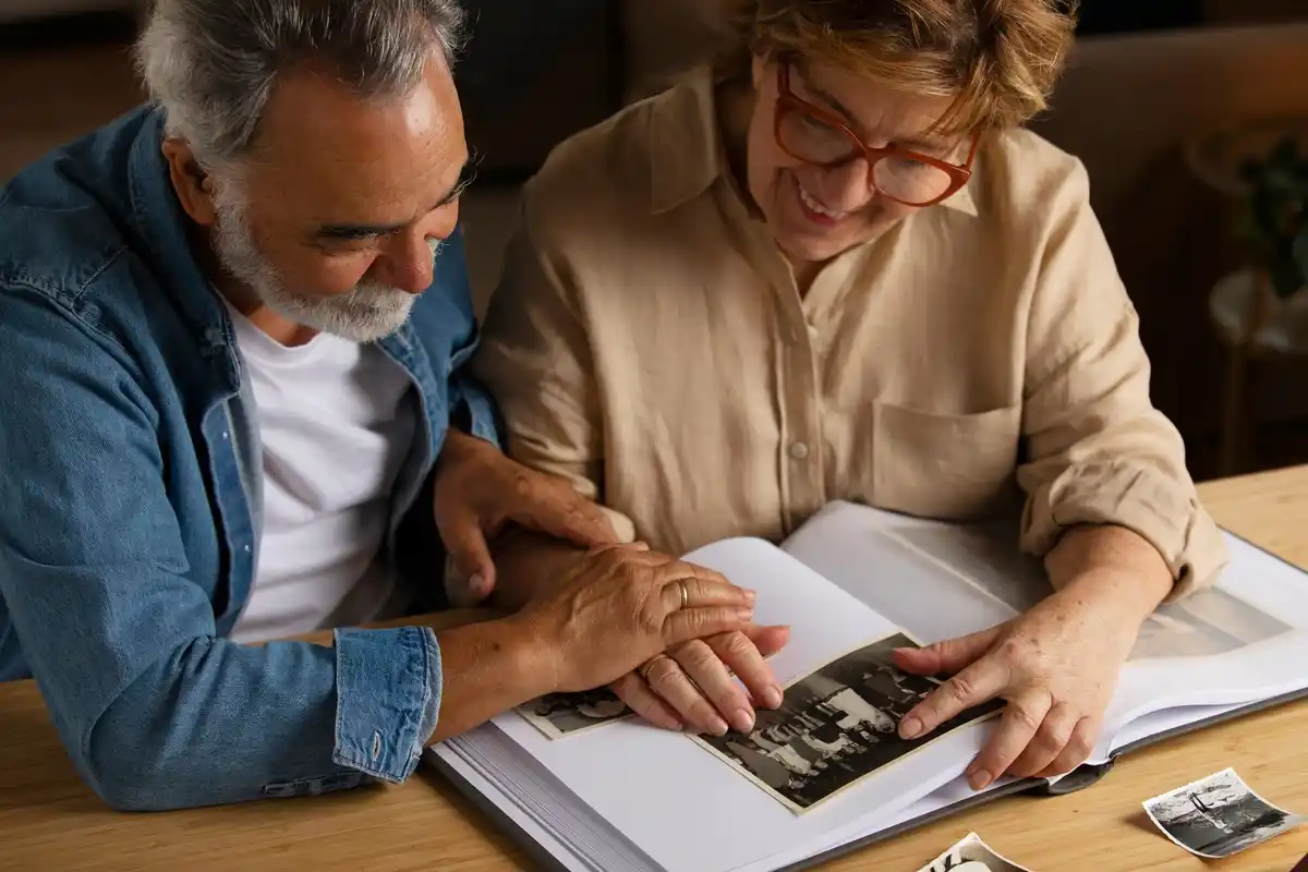 happy couple looking at old family photos at home