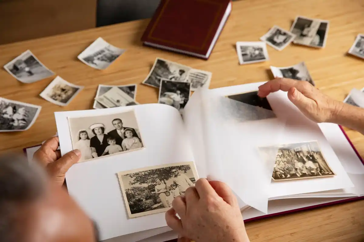 oud fotoboek op houten tafel met handen van stel
