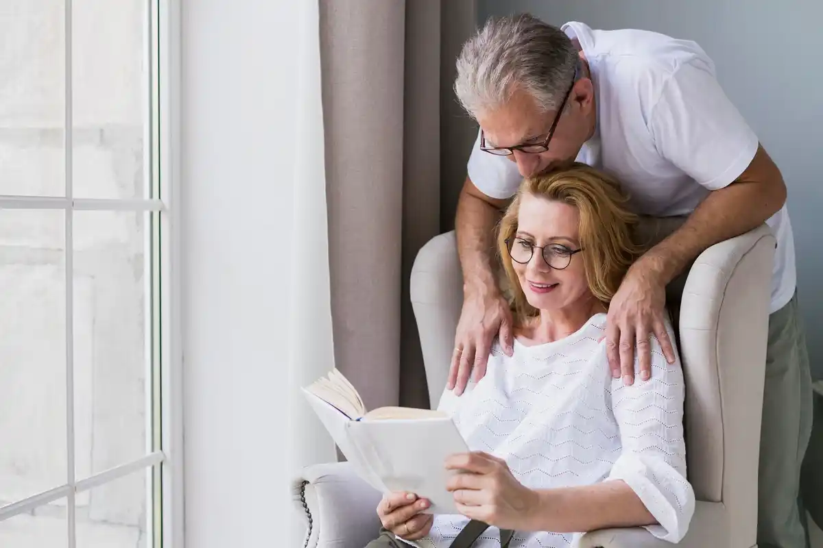 stel in woonkamer lacht samen terwijl ze oude foto's bekijken