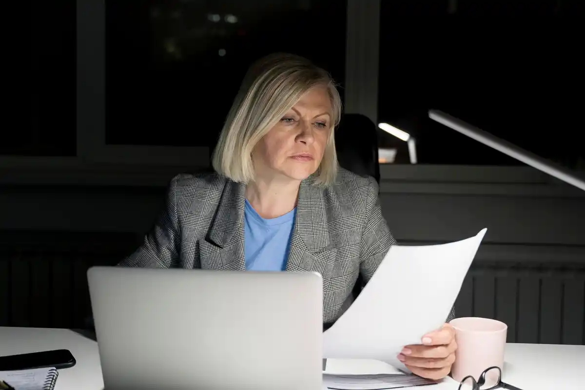 frustrated dutch woman at laptop viewing low bank interest