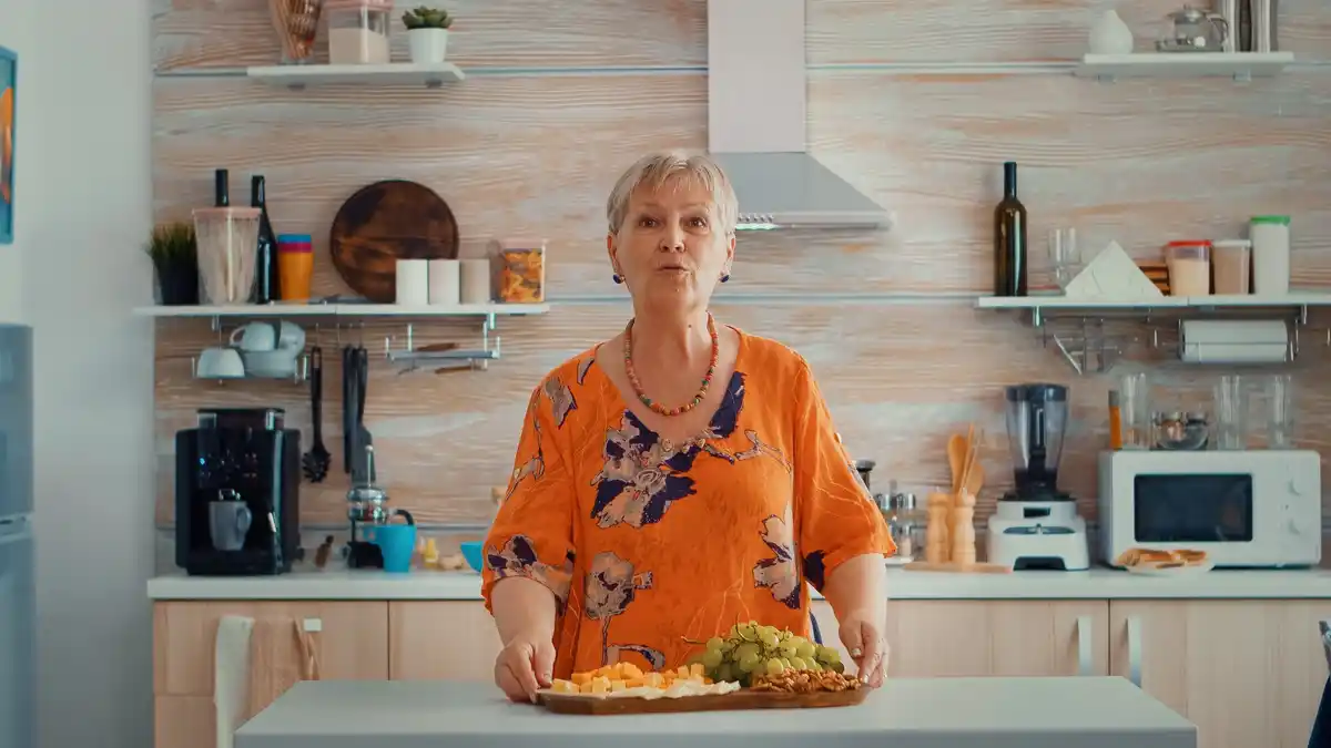 elderly dutch woman organizing kitchen shelf smiling