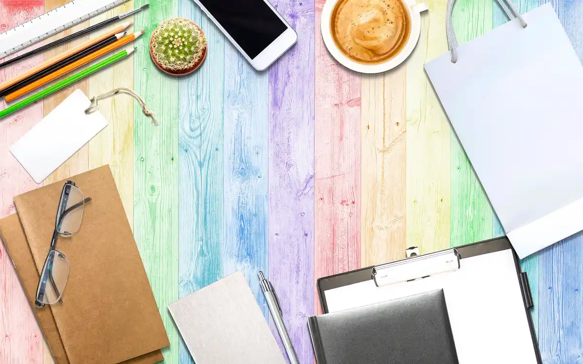 busy desk covered in colorful post-it notes and abandoned planners