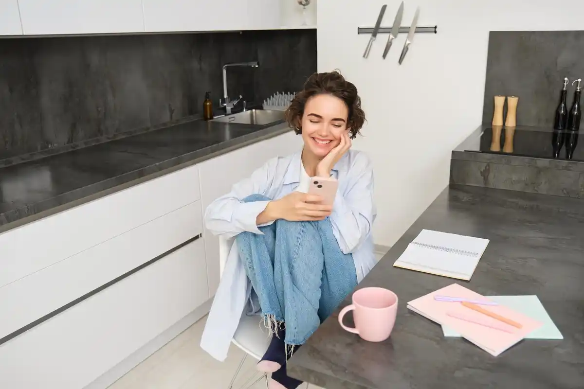 dutch woman multitasking home kitchen laptop phone