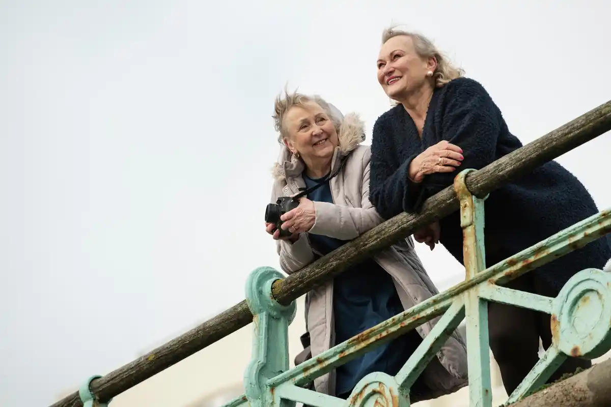 Dutch grandmothers laughing together in the park on a cloudy day