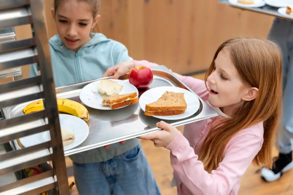 children refusing bread crust at breakfast table, Dutch kitchen