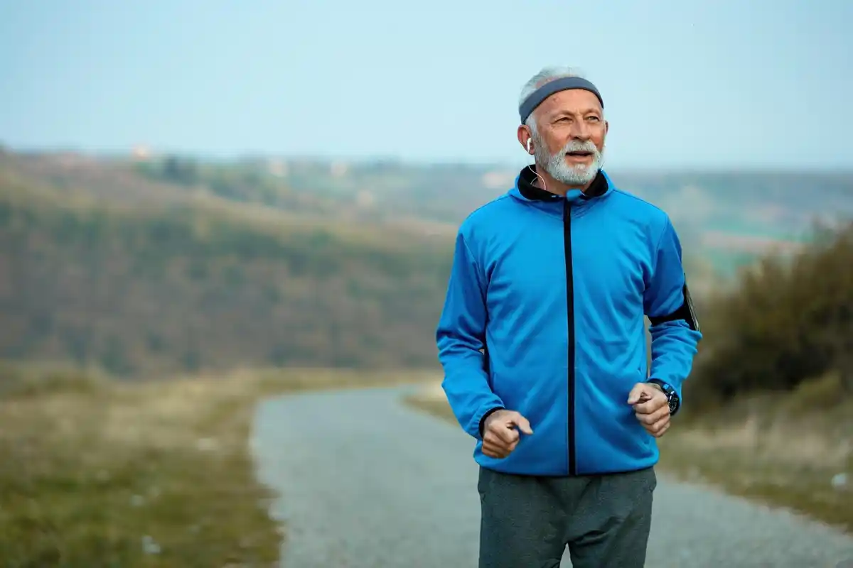 fit mature man running in park sunny morning Netherlands