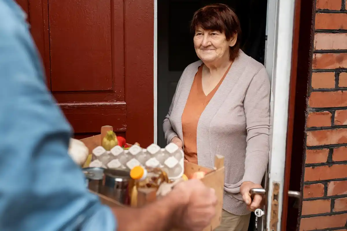dutch elderly woman taking bread from freezer