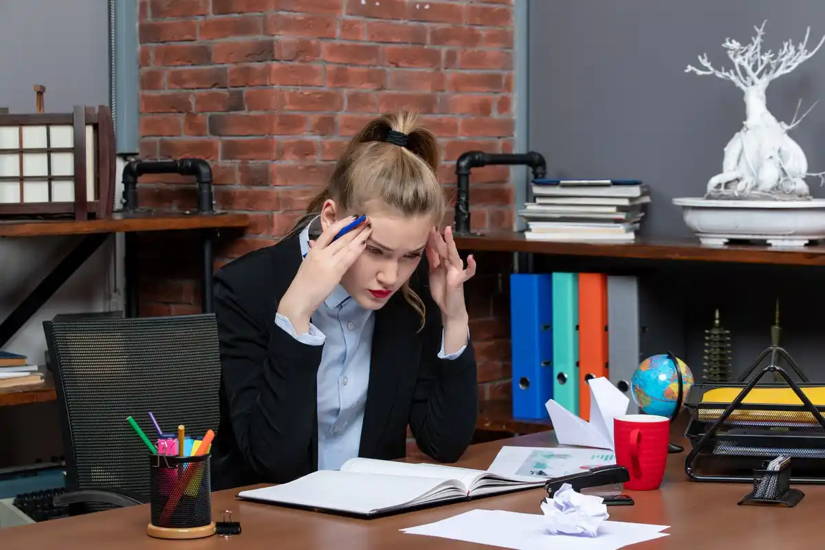 stressed businesswoman multitasking at office desk