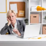 person frustrated with digital productivity tools on desk