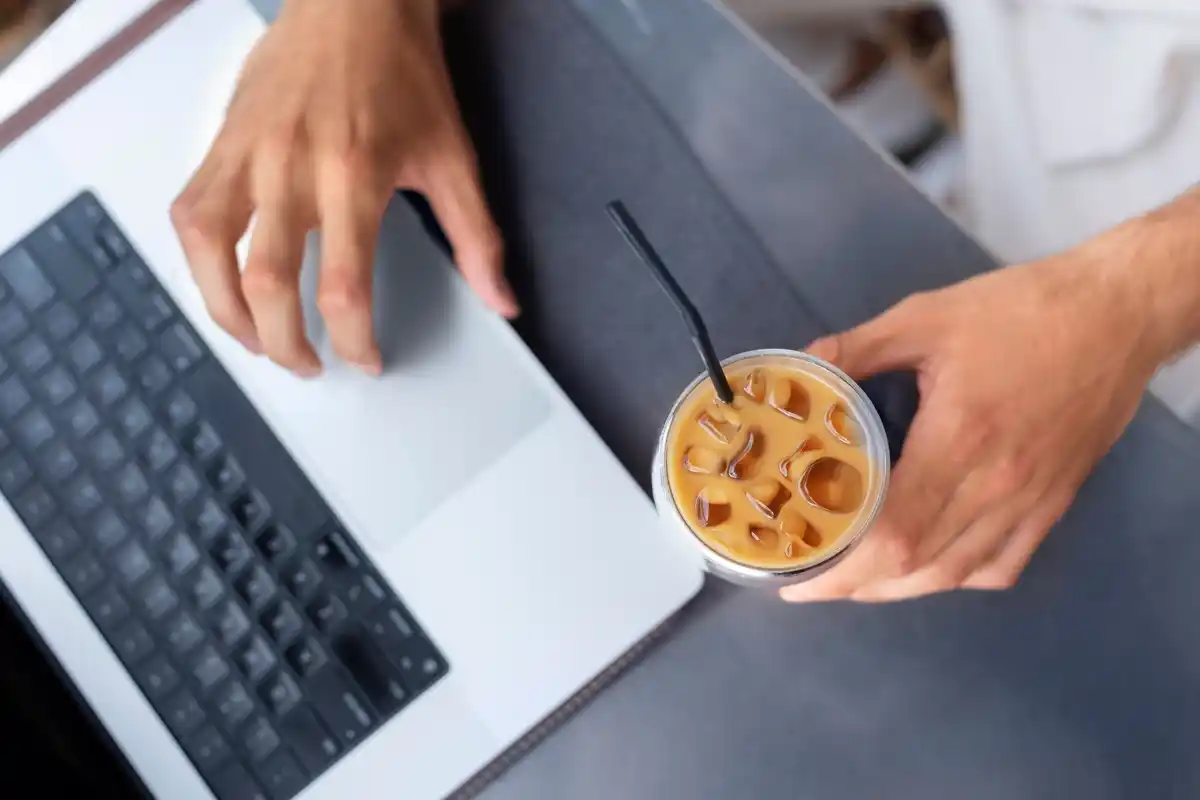 closeup hands budgeting app dutch cafe laptop coffee