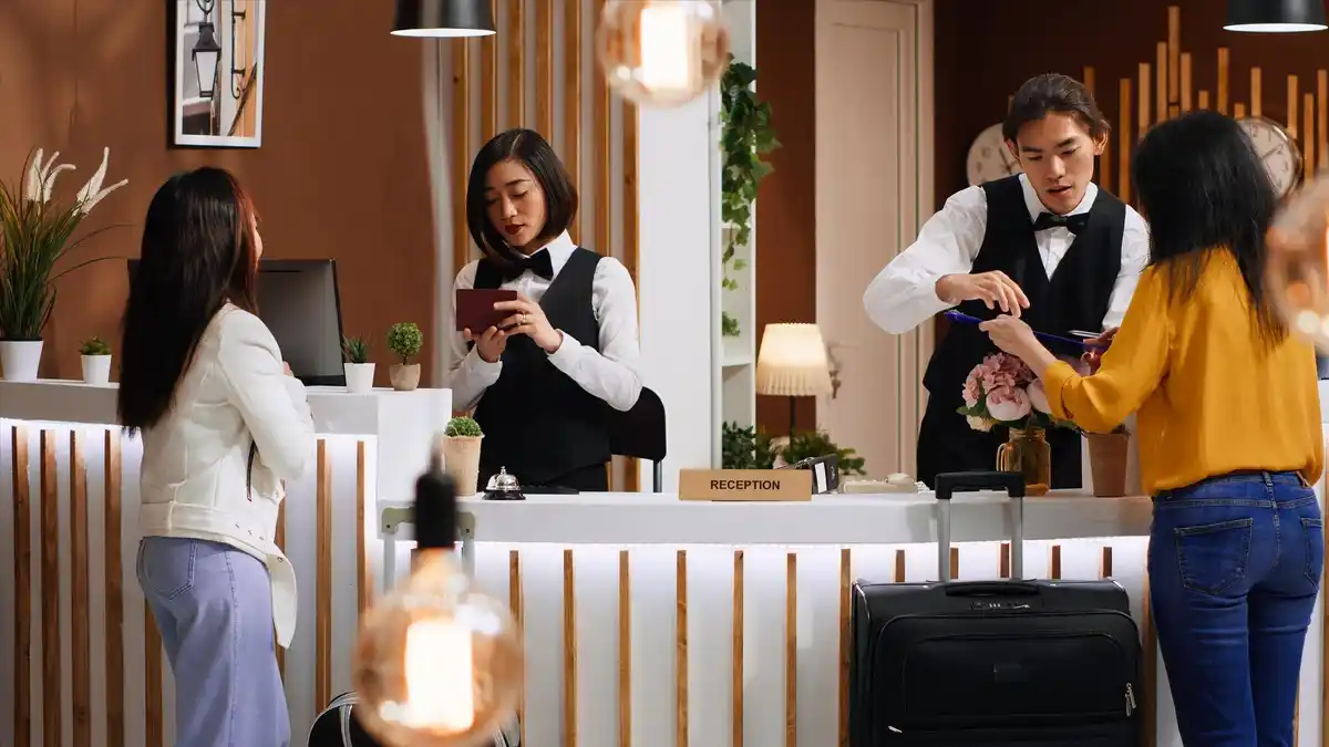 happy hotel guest at reception desk upgrade moment