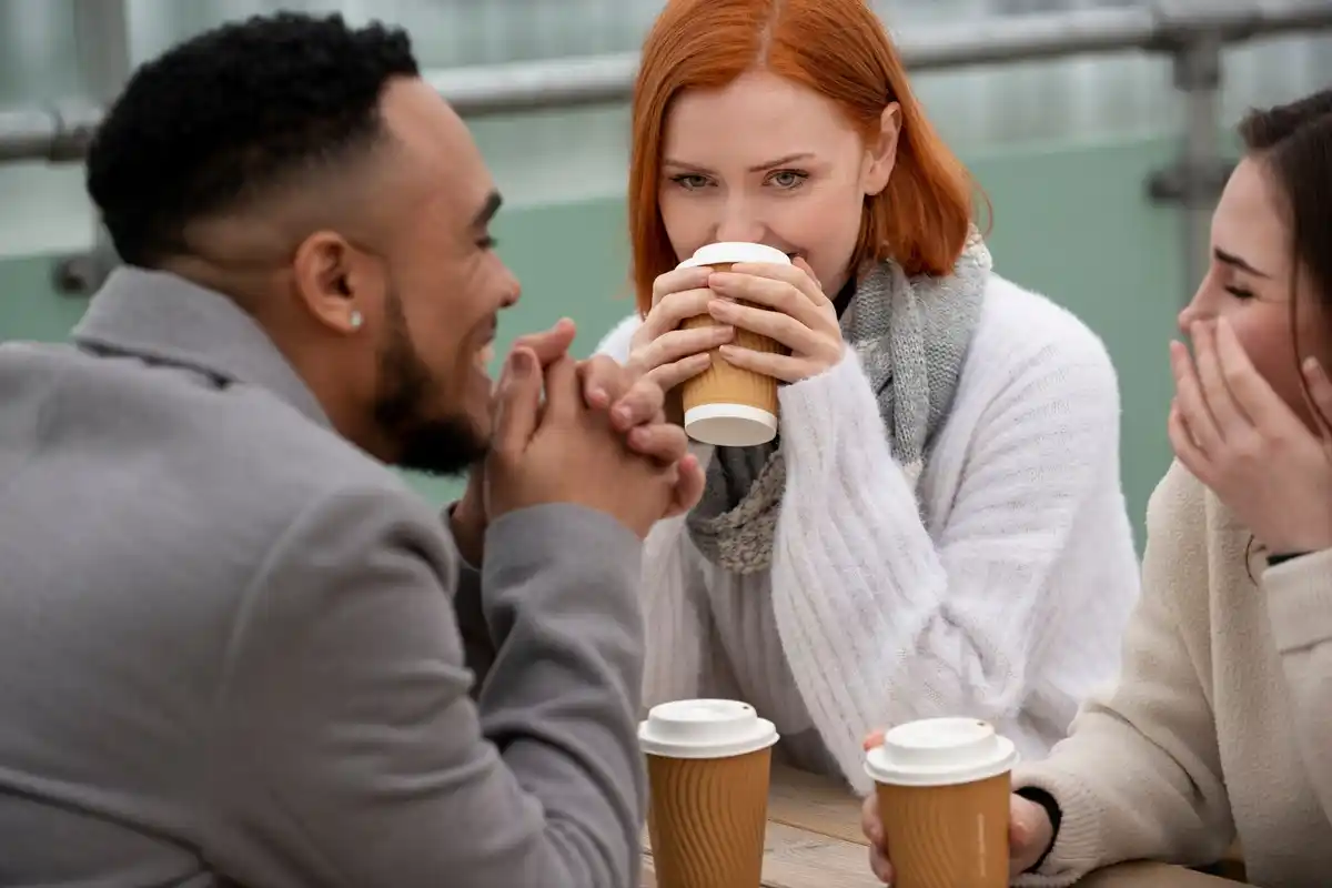 Millennials discussing conflict, Dutch workspace, coffee mugs on the table