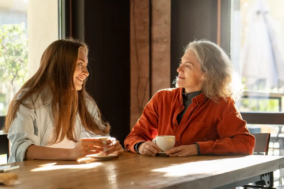 middle aged friends laughing and talking in dutch cafe