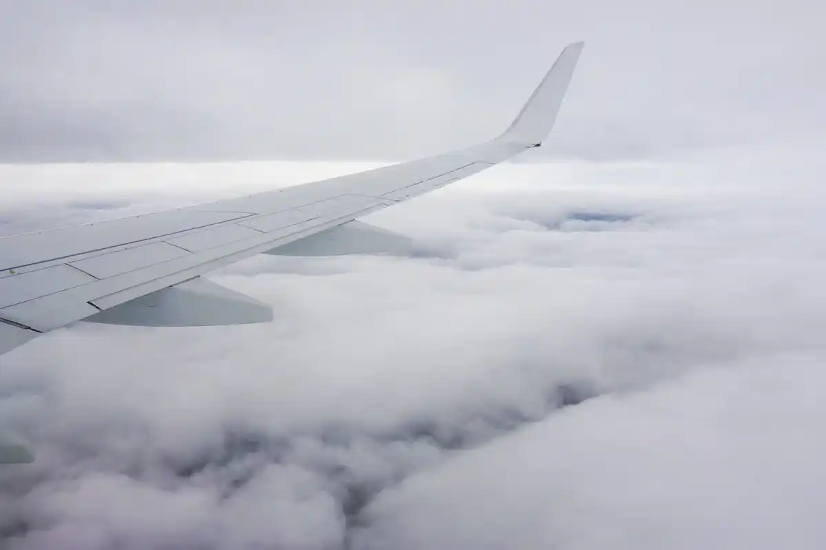 Aerial view airplane wing Schiphol clouds Netherlands