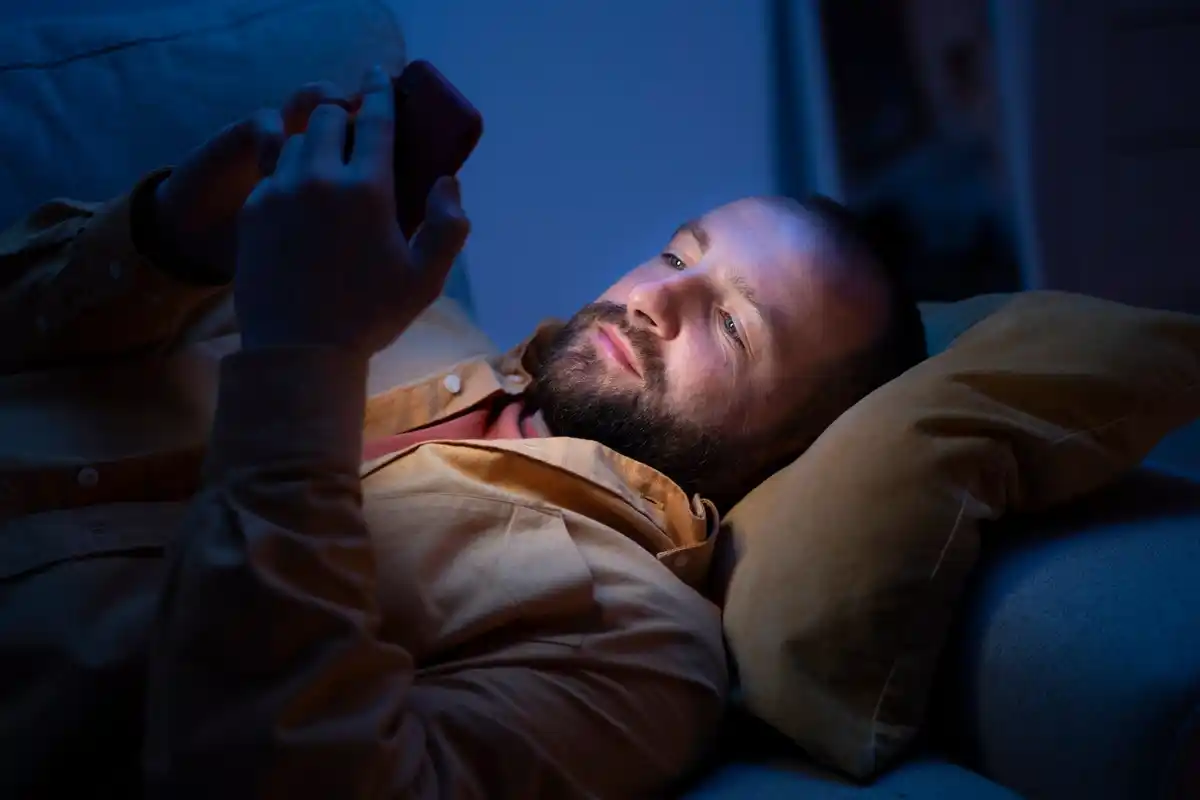 man relaxing with 4-7-8 breathing at night bedroom lamp