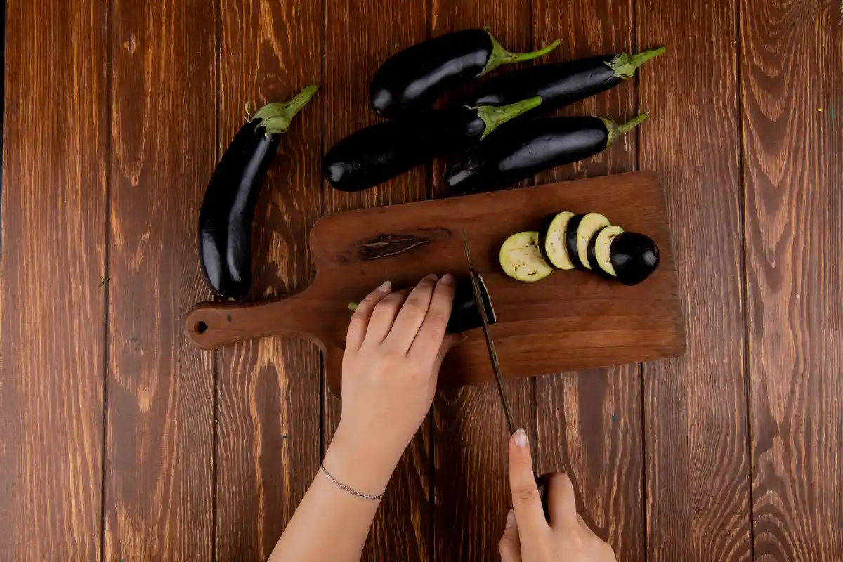 old woman's hands preparing food on cutting board with aluminium foil